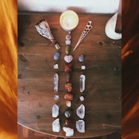 a table with stones, crystals, and a candle on it