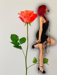 a woman in a black dress is posing next to a rose