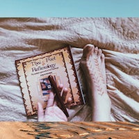 a person laying on a bed with a book